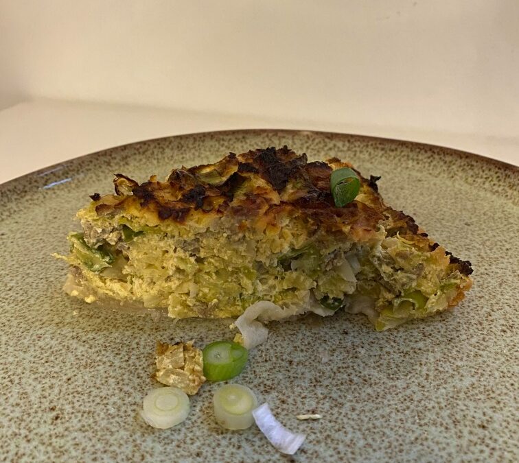 Savooie Spitskoolquiche part geserveerd met bosui.